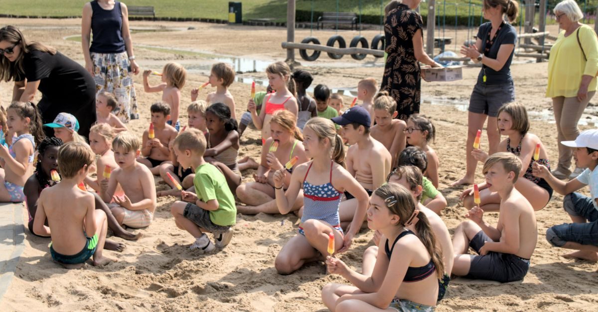 Kinderen genieten van een waterijsje in de waterspeeltuin