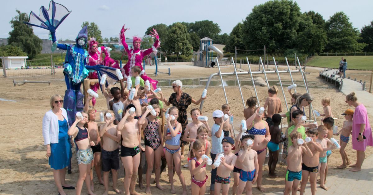 Kinderen genieten van de drinkbus die ze van Pidpa kregen